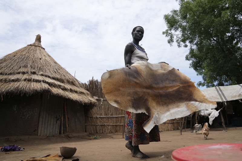 A woman carries antelope skin outside her house in Otallo village, South Sudan, Wednesday, June 19, 2024. The country's first comprehensive aerial wildlife survey, released Tuesday, June 25, found about 6 million antelope. (AP Photo/Brian Inganga)