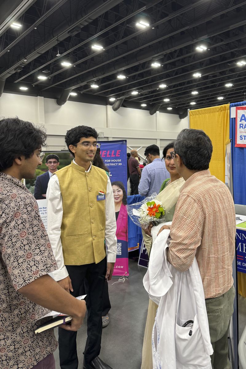 Democratic candidate Ashwin Ramaswami, second left, speaks to people at the Festival of India Saturday, Aug. 17, 2024, in Duluth, Ga. (AP Photo/Charlotte Kramon)