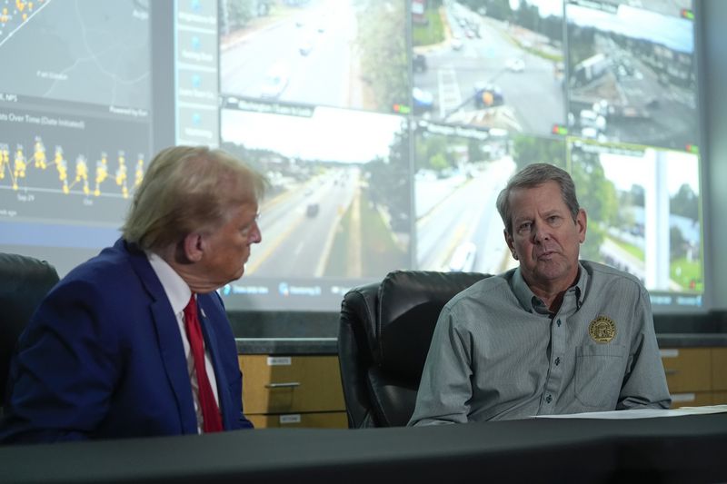 Republican presidential nominee former President Donald Trump talks with Georgia Gov. Brian Kemp during a briefing at the Columbia County Emergency Management Agency as he visits areas impacted by Hurricane Helene, Friday, Oct. 4, 2024, in Evans, Ga. (AP Photo/Evan Vucci)