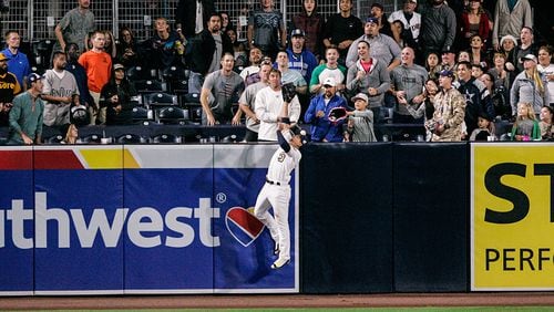 San Diego Padres outfielder Jon Jay jumps at the wall as the ball hit by Braves' Freddie Freeman bounces back to the field in the ninth inning at PETCO Park June 7, 2016, in San Diego.