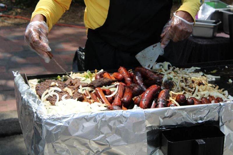 A vendor at the 21st Annual Juneteenth Celebration in Marietta cooks Chicago-style polish sausage on Saturday. (Photo Courtesy of Isabelle Manders)