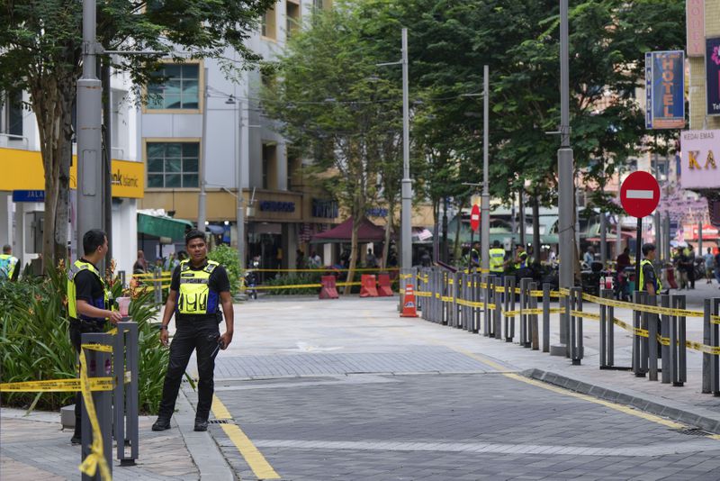 Police stand guard on a closed roadside after another deep sinkhole appeared a week after a woman fell into a sinkhole when a sidewalk caved in in Kuala Lumpur, Thursday, Aug. 29, 2024. (AP Photo/Vincent Thian)