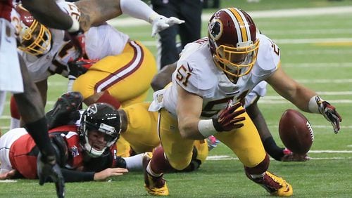 Falcons quarterback Matt Ryan (left) fumbles the ball way as he is brought down and Redskins linebacker Will Compton recovers the fumble during the second quarter in their football game on Sunday, Oct. 11, 2015, in Atlanta.