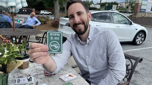 "Atlanta Traffic: The Card Game" creator Evan Simmons demonstrates his clever, humorous card game at a Roswell coffee shop on May 15th, 2024." Credit: Doug Turnbull/WSB Traffic