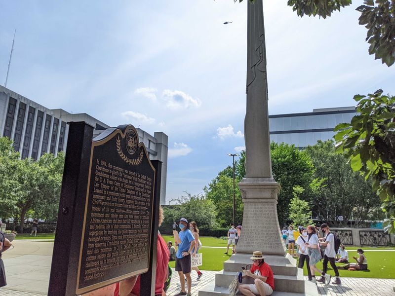 The Decatur protesters paid no heed to a silent argument about race in their midst: a century-old obelisk outside the old DeKalb County courthouse in memory of the "lost cause," glorifying the Civil War Confederacy, and a recent retort by the county commission, which is prohibited by state law from removing it. The commission installed a placard saying the obelisk "bolstered white supremacy and faulty history" and that the Civil War was started over slavery.