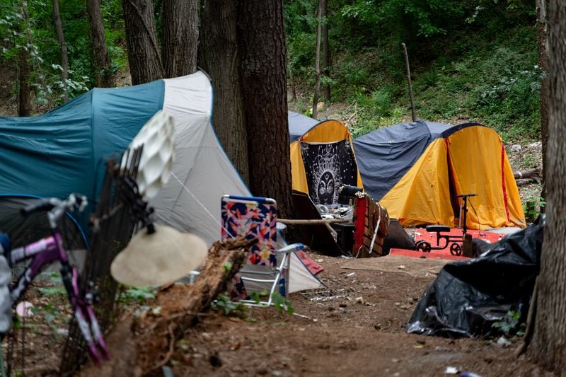 Multiple tents are set up in the woodline next to interstate 85. Tracy Woodard is a social worker with InTown Cares, a homeless advocacy group serving the Atlanta metro area. Friday, May 17, 2024 (Ben Hendren for the Atlanta Journal Constitution)