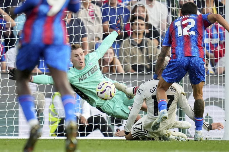 Crystal Palace's goalkeeper Dean Henderson goes for a save in front of Manchester United's Alejandro Garnacho during the English Premier League soccer match between Crystal Palace and Manchester United at Selhurst Park in London, Saturday, Sept. 21, 2023. (AP Photo/Kin Cheung)