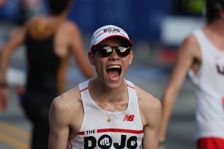 Runner Trevor Dunkel yells after he crosses the finish line at the  55th running of the Atlanta Journal-Constitution Peachtree Road Race in Atlanta on Thursday, July 4, 2024.   (Jason Getz / AJC)