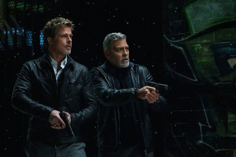 This image released by Apple TV+ shows Brad Pitt, left, and George Clooney in a scene from "Wolfs." (Scott Garfield/Apple TV+ via AP)