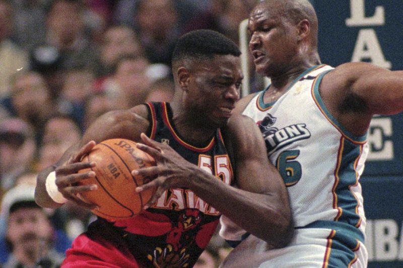 FILE - Atlanta Hawks center Dikembe Mutombo, left, pushes up on Detroit Pistons center Terry Mills during the first quarter in Auburn Hills, Mich., Friday, May 2, 1997. (AP Photo/Carlos Osorio, File)