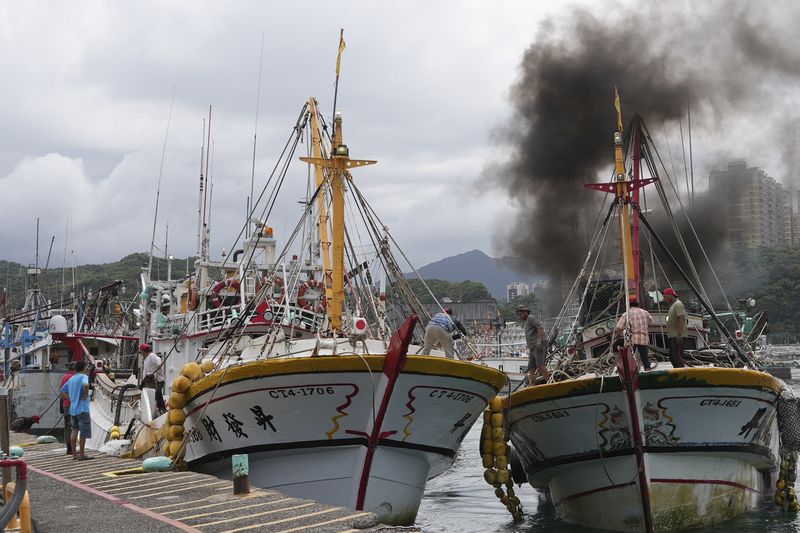 Workers tighten boats with ropes before Typhoon Krathon arrives, at a harbor in Keelung, Taiwan, Monday, Sept. 30, 2024. (AP Photo/Johnson Lai)