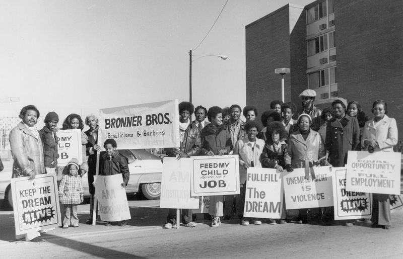 Bronner Bros. founder Nathaniel Bronner Sr., standing left of the sign bearing his name, poses for a photo with members of his staff and their families in the mid-1970s. File photo courtesy of the Bronner family