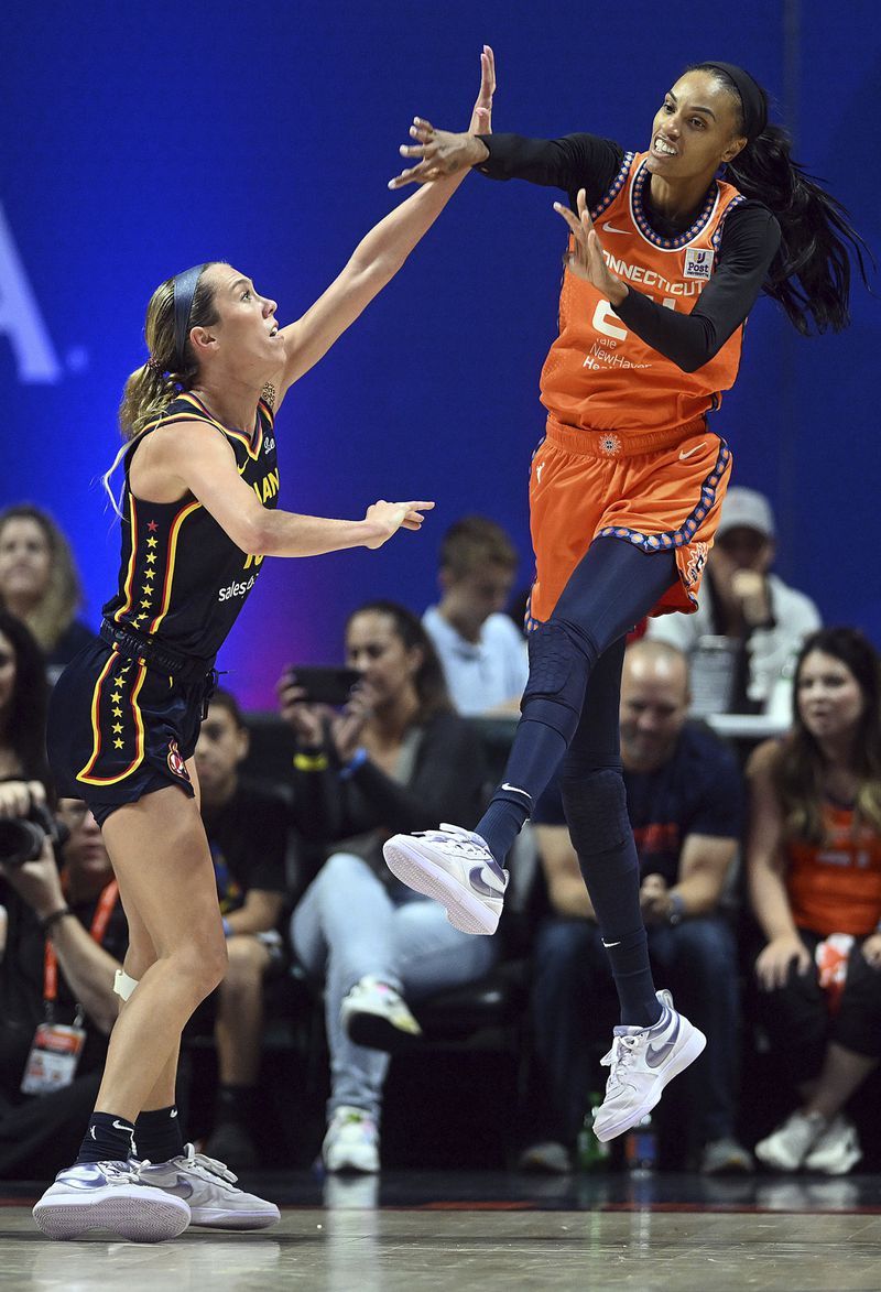 Connecticut Sun's DeWanna Bonner, right, throws a pass past Indiana Fever's Lexie Hull, left, during a first-round WNBA basketball playoff game at Mohegan Sun Arena, Sunday, Sept. 22, 2024. (Sarah Gordon/The Day via AP)