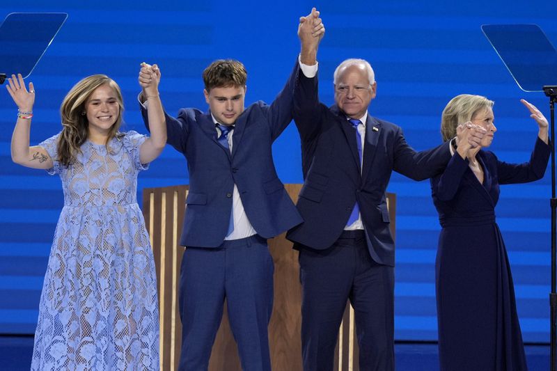 Democratic vice presidential nominee Minnesota Gov. Tim Walz, second from right, poses with his wife Gwen Walz, from right, son Gus Walz and daughter Hope Walz after speaking during the Democratic National Convention Wednesday, Aug. 21, 2024, in Chicago. (AP Photo/J. Scott Applewhite)