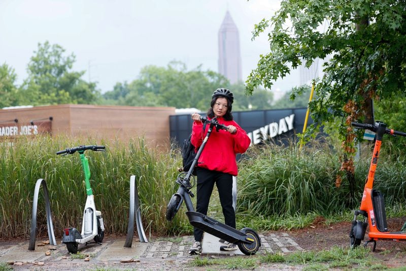 Mona Su, who lives in Midtown, lifts her scooter as she gets ready to head home after a quick trip to the market near Beltline on Monday, July 22, 2024. For Mona Su, riding scooters is a car-free lifestyle that provides an easy and reliable commuting alternative.
(Miguel Martinez / AJC)