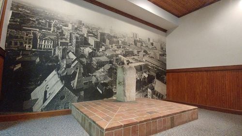 The Zero Mile Post, seen here on April 19, 2018 has been in place since 1850 and marks the terminus of the first rail line built to the place that would become Atlanta. A building was constructed around the post in the 1980s, protecting the landmark and creating a sort of mini-museum. That building is now slated for demolition in late 2018 or early 2019. A large poster image of downtown Atlanta in the early 20th century serves as a backdrop. (William Thweatt / wthweatt@ajc.com)