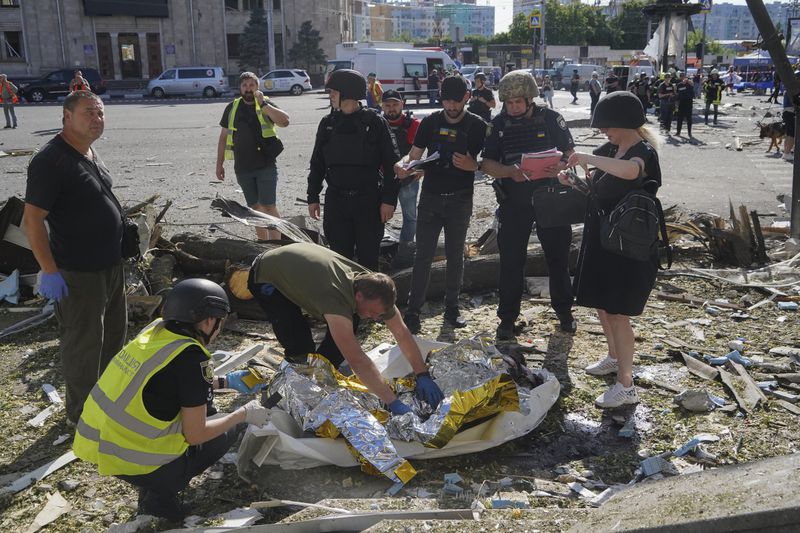 Police officers inspect a dead body after Russian attack in Kharkiv, Ukraine, Saturday, June 22, 2024. At least three people were killed in a Russian bomb attack on Ukraine’s second city, Kharkiv, on Saturday afternoon, Ukrainian President Volodymyr Zelenskyy said. (AP Photo/Andrii Marienko)