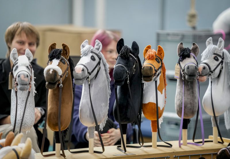 A vendor offers hobby horses for sale at the first German Hobby Horsing Championship in Frankfurt, Germany, Saturday, Sept. 14, 2024. (AP Photo/Michael Probst)