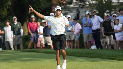 Charlie Woods signals after hitting off the 18th tee during the second round of stroke play of the U.S. Junior Amateur Golf Championship, Tuesday, July 23, 2024, in Bloomfield Township, Mich. (AP Photo/Carlos Osorio)