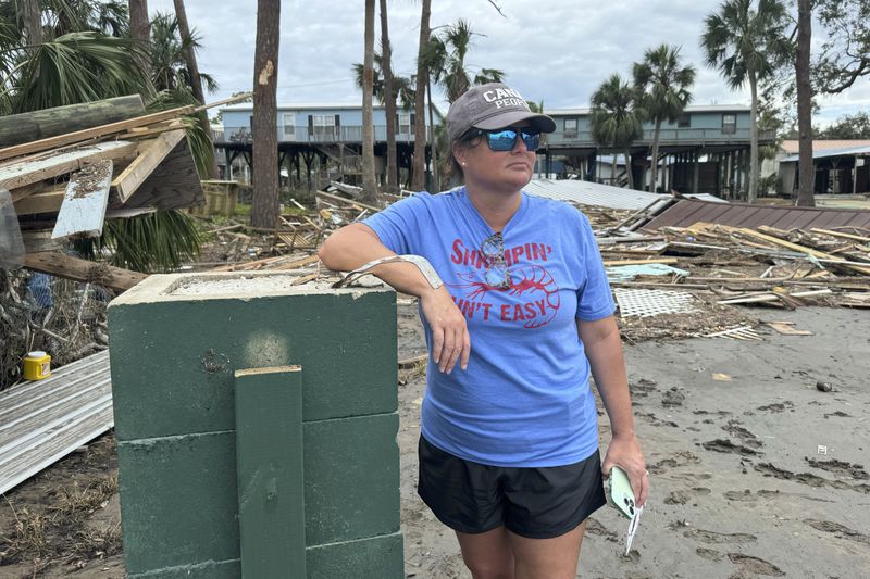 Brooke Hiers stands in front of where her home used to sit in Horseshoe Beach, Fla., Monday, Sept. 30, 2024, in the aftermath of Hurricane Helene. She and her husband had just rebuilt the home after Hurricane Idalia hit in August, 2023, before Hurricane Helene blew the house off its pilings and floated it into the neighbor's yard next door. (AP Photo/Kate Payne)