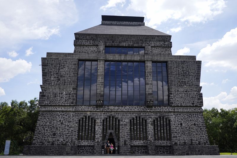 Visitors exit the Anahuacalli Museum in Mexico City, Tuesday, Aug. 20, 2024. Built by Mexican artist Diego Rivera, its name, Anahuacalli, translates from the Nahuatl language as "house surrounded by water." (AP Photo/Eduardo Verdugo)