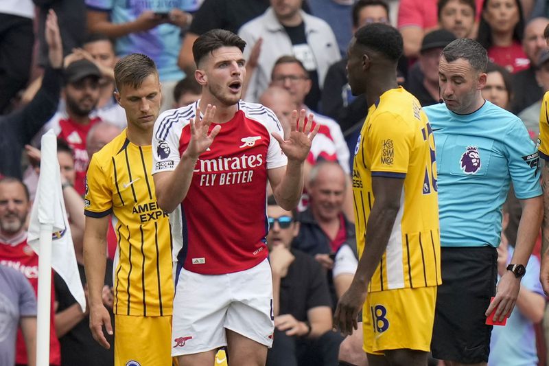 Arsenal's Declan Rice, left, discusses with Brighton's Danny Welbeck during the English Premier League soccer match between Arsenal and Brighton, at Emirates Stadium in London, Saturday, Aug. 31, 2024. (AP Photo/Alastair Grant)