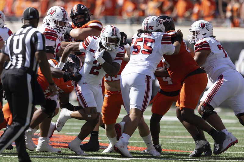 Utah running back Micah Bernard (2) runs past Oklahoma State defensive end Obi Ezeigbo (33) in the first half of an NCAA college football game Saturday, Sept. 21, 2024, in Stillwater, Okla. (AP Photo/Mitch Alcala)