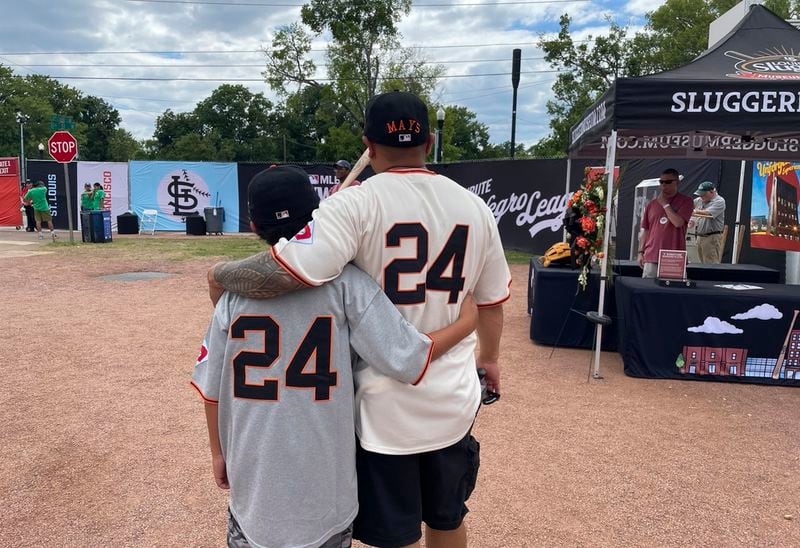 Eddie Torres, right, and son Junior, from California and wearing San Francisco Giants uniforms with Willie Mays' No. 24 on the back, pose at Rickwood Field on Thursday, June 20, 2024, in Birmingham, Ala. (AP Photo/Alanis Thames)