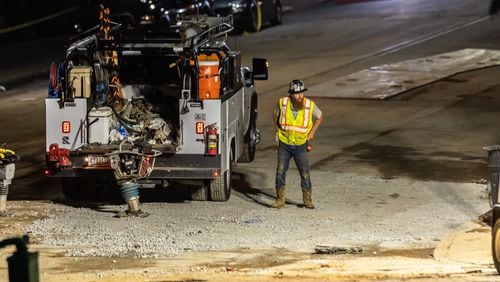 Workers continued to put the finishing touches on the filled in water main hole Wednesday morning, June 5, 2024 following the city’s announcement that water had been restored following the break on West Peachtree Street and 11th Street. The city said the system was being brought back online slowly to “allow system pressures to build.” (John Spink/AJC)