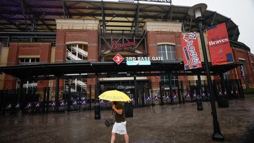 A person with an umbrella walks outside Truist Park on Wednesday, Sept. 25, 2024. Due to the weather, the game between the Atlanta Braves and the New York Mets today and tomorrow will be played as a doubleheader on Monday.
(Miguel Martinez/ AJC)