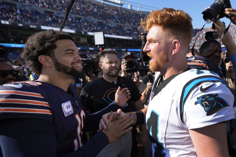 Chicago Bears quarterback Caleb Williams, left, and Carolina Panthers quarterback Andy Dalton, right, talk after an NFL football game Sunday, Oct. 6, 2024, in Chicago. (AP Photo/Charles Rex Arbogast)