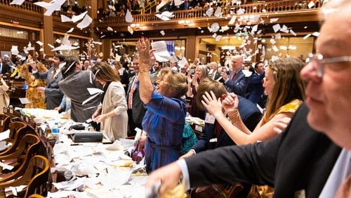 State representatives throw paper in the air early Friday to celebrate the end of the legislative session in the House of Representatives. (Arvin Temkar / arvin.temkar@ajc.com)