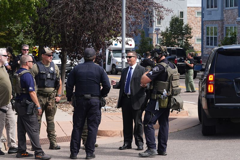 Law enforcement officials gather outside a building following a shooting at an apartment complex Thursday morning, Sept. 12, 2024, in Broomfield, Colo., a suburb of Denver. (AP Photo/David Zalubowski)