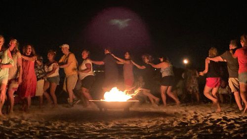 Members of the Apex Christian Singles dance around a campfire at their annual beach retreat in Panama City Beach. 
(Courtesy of Debbie Perdue)