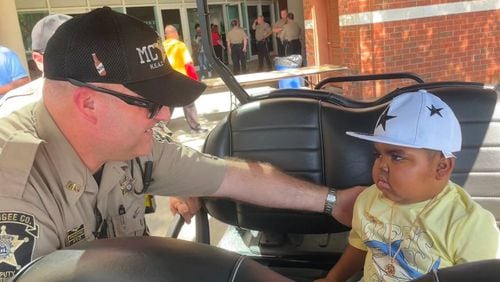 4-year-old Armon is given a sheriff pin by one of the Muscogee County sheriff's deputies. (Photo Courtesy of Bea Lunardini)