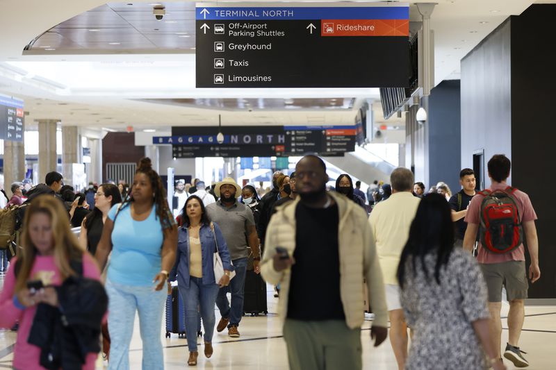 People walk through the arrival area at the Hartsfield-Jackson International Airport on Thursday, May 26, 2022. About 2 million passengers are expected to pass through its concourses during the Memorial Day holiday from May 26 to June 1. Miguel Martinez / miguel.martinezjimenez@ajc.com