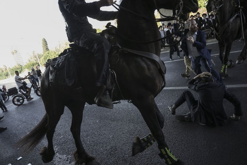 Israeli mounted police officers disperse Ultra-Orthodox Jews blocking a highway during a protest against army recruitment in Bnei Brak, Israel, Thursday, June 27, 2024. Israel's Supreme Court unanimously ordered the government to begin drafting ultra-Orthodox Jewish men into the army — a landmark ruling seeking to end a system that has allowed them to avoid enlistment into compulsory military service. (AP Photo/Oded Balilty)