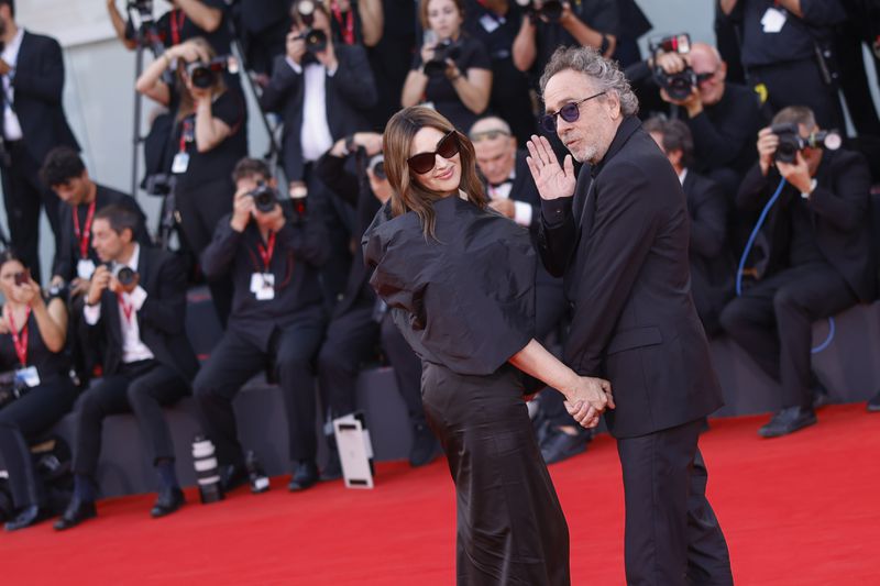 Monica Bellucci, left, and director Tim Burton pose for photographers upon arrival for the premiere of the film 'Beetlejuice Beetlejuice' and the opening ceremony of the 81st edition of the Venice Film Festival in Venice, Italy, on Wednesday, Aug. 28, 2024. (Photo by Vianney Le Caer/Invision/AP)