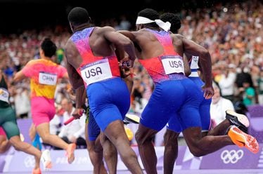 Christian Coleman, left, of the United States, struggles to hand the baton to teammate Kenneth Bednarek, in the men's 4x100-meter relay final at the 2024 Summer Olympics, Friday, Aug. 9, 2024, in Saint-Denis, France. (AP Photo/Bernat Armangue)