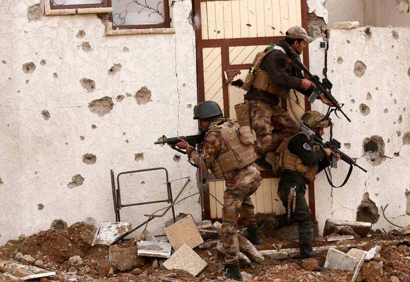 FILE - Soldiers with Iraq's elite counterterrorism forces secure houses and streets during fighting against Islamic State militants to regain control of the eastern neighborhoods of Mosul, Iraq, Dec. 13, 2016. Ten years after the Islamic State group declared its caliphate in large parts of Iraq and Syria, the extremists now control no land, have lost many prominent founding leaders and are mostly away from the world news headlines. (AP Photo/Hadi Mizban, File)