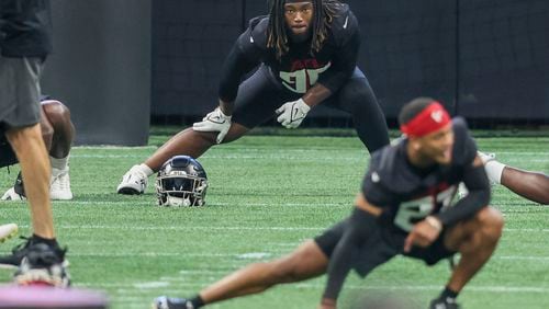 Atlanta Falcons defensive lineman Ta’Quon Graham, top, stretches with teammates during minicamp at Mercedes-Benz Stadium, Tuesday, June 13, 2023, in Atlanta. (Jason Getz / Jason.Getz@ajc.com)