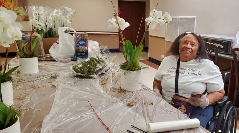 Evette Oates helps prepare orchid centerpieces for a luncheon as part of a horticultural therapy session during a Generation Connect summer service camp at A.G. Rhodes.