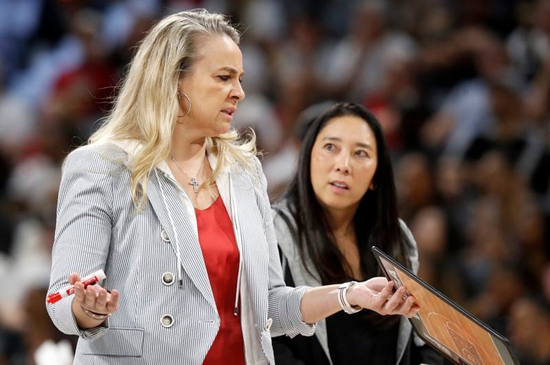 Las Vegas Aces head coach Becky Hammon, left, talks with assistant coach Natalie Nakase during the first half of a WNBA basketball game against the Connecticut Sun, Sunday, Sept. 15, 2024, in Las Vegas. (Steve Marcus/Las Vegas Sun via AP)