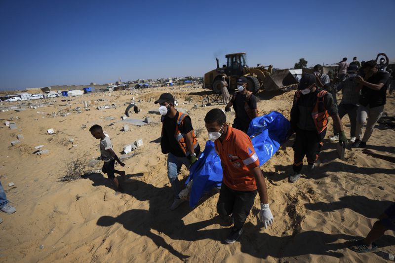 People bury the bodies of Palestinians taken by the Israeli military during operations in Gaza and returned this week, in Khan Younis, Gaza Strip, Thursday, Sept. 26, 2024. (AP Photo/Abdel Kareem Hana)