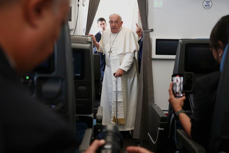 Pope Francis attends a news conference aboard the papal plane on his flight back after his 12-day journey across Southeast Asia and Oceania, Friday, Sept. 13, 2024. (Guglielmo Mangiapane/Pool Photo via AP)