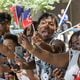 Chauncey Delaney (Center) cheers on the parade as it moves up Decatur St towards Centennial Park during the Juneteenth Atlanta Parade and Music Festival Saturday, June 17, 2023.   (Steve Schaefer/steve.schaefer@ajc.com)