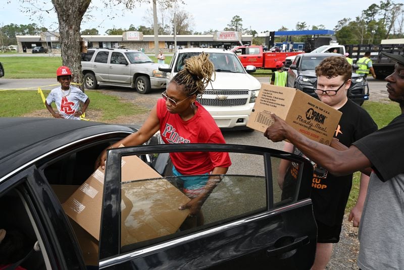 Jalisa Smith (center) and other volunteers hand out free meal kits, tarp and waters at the parking lot of Willacoochee City Hall, Tuesday, October 1, 2024 in Willacoochee. Recovery efforts continue Sunday across Georgia’s 159 counties after Helene barreled through the state, causing catastrophic damage, flooding and at least 17 deaths. More than 400,000 people were still without power statewide after Helene entered South Georgia as a Category 2 hurricane around 1 a.m. Friday. Homes were destroyed, and neighborhoods were flooded across the state. (Hyosub Shin / AJC)