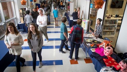 Parents and potential new students walk the halls of North Springs Charter High School during the school’s open house Sunday in Sandy Springs.