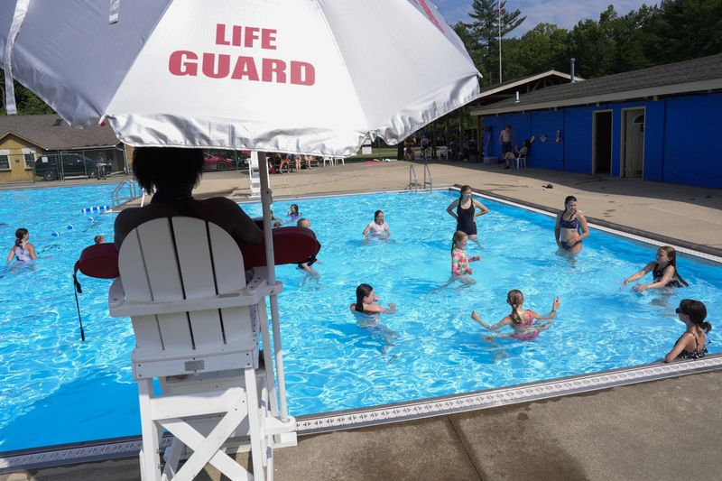Campers swim in the pool, Thursday, June 20, 2024, at YMC Camp Kern in Oregonia, Ohio. As the first heat wave of the season ripples across the U.S., summer camps are working to keep their children cool while still letting the kids enjoy being outside with nature. (AP Photo/Joshua A. Bickel)