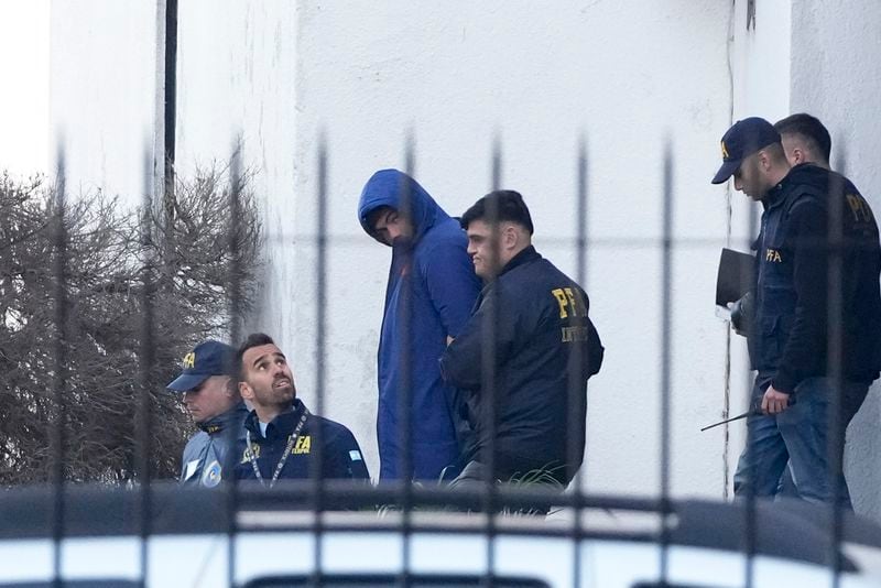 Police escort French rugby player Hugo Auradou, center, in Buenos Aires, Argentina, Thursday, July 11, 2024. Players Oscar Jegou and Auradou were arrested following a formal complaint was filed against them for alleged sexual assault, after France played Argentina in a test rugby match in Mendoza on July 6. (AP Photo/Natacha Pisarenko)